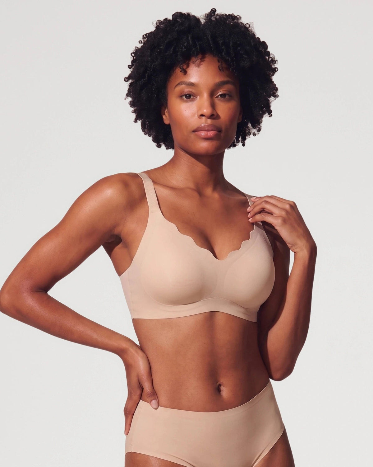 PLERIVA Scalloped Wireless Lift Bra in Nude, front view on model with hands on hips