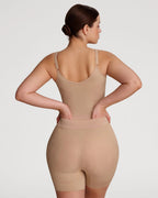 PLERIVA Seamless Full Body Sculpting Bodysuit in Nude, back view on model with hands on hips