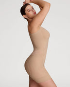 PLERIVA Seamless Full Body Sculpting Bodysuit in Nude, side view on model with arms raised