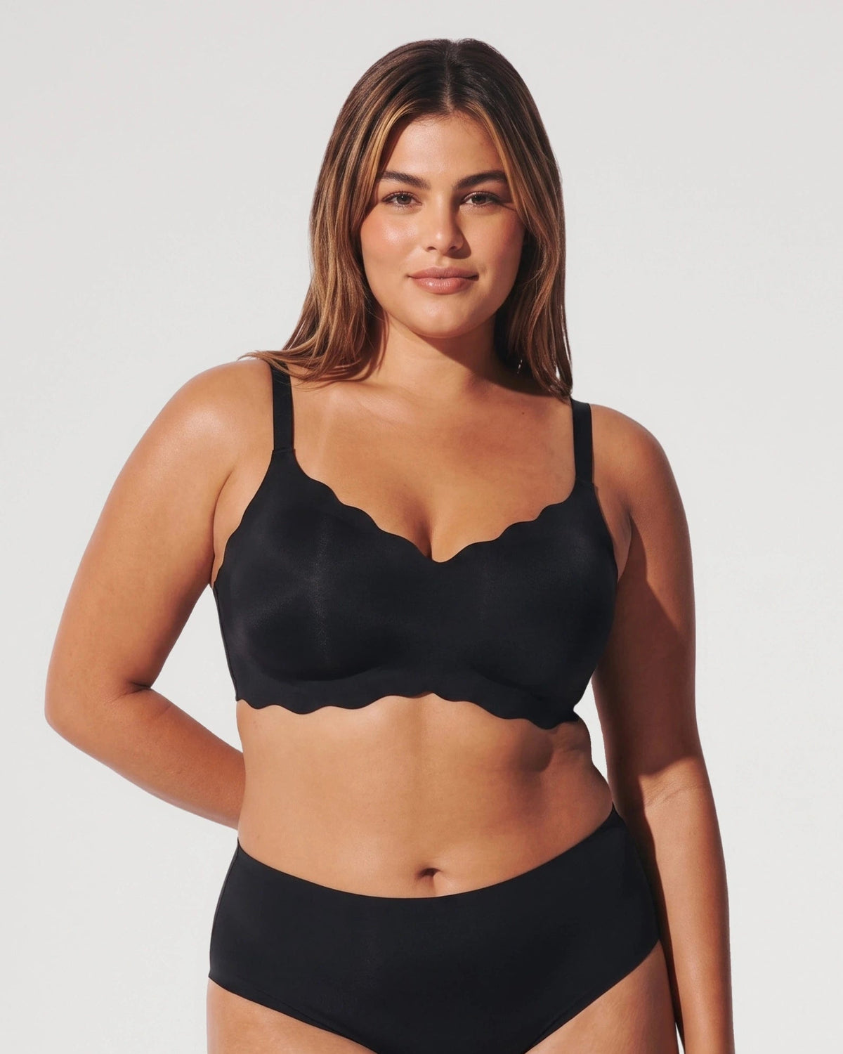 PLERIVA Seamless Scalloped Wireless Bra in Black, front view on model with matching brief
