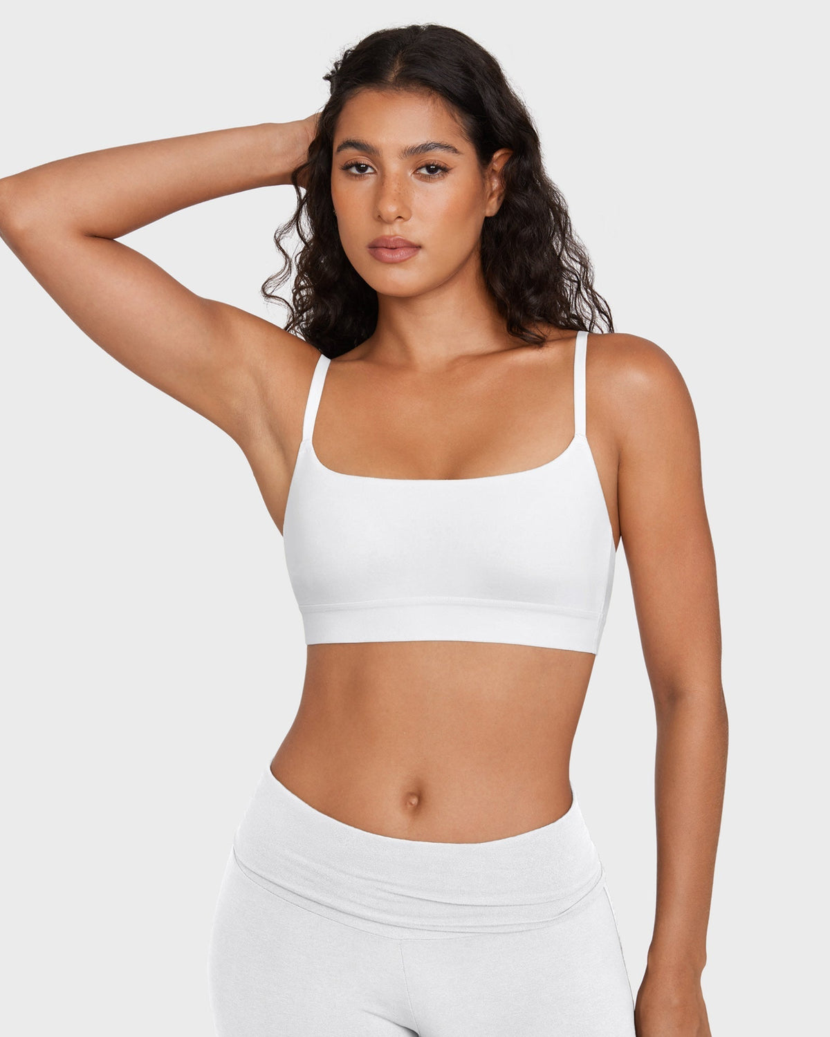 PLERIVA Unlined Scoop Neck Wireless Bralette in White, front view with arm raised